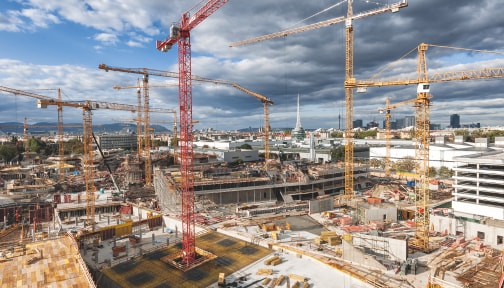 stadsvy av mängder av byggarbetsplatser och lyftkranar