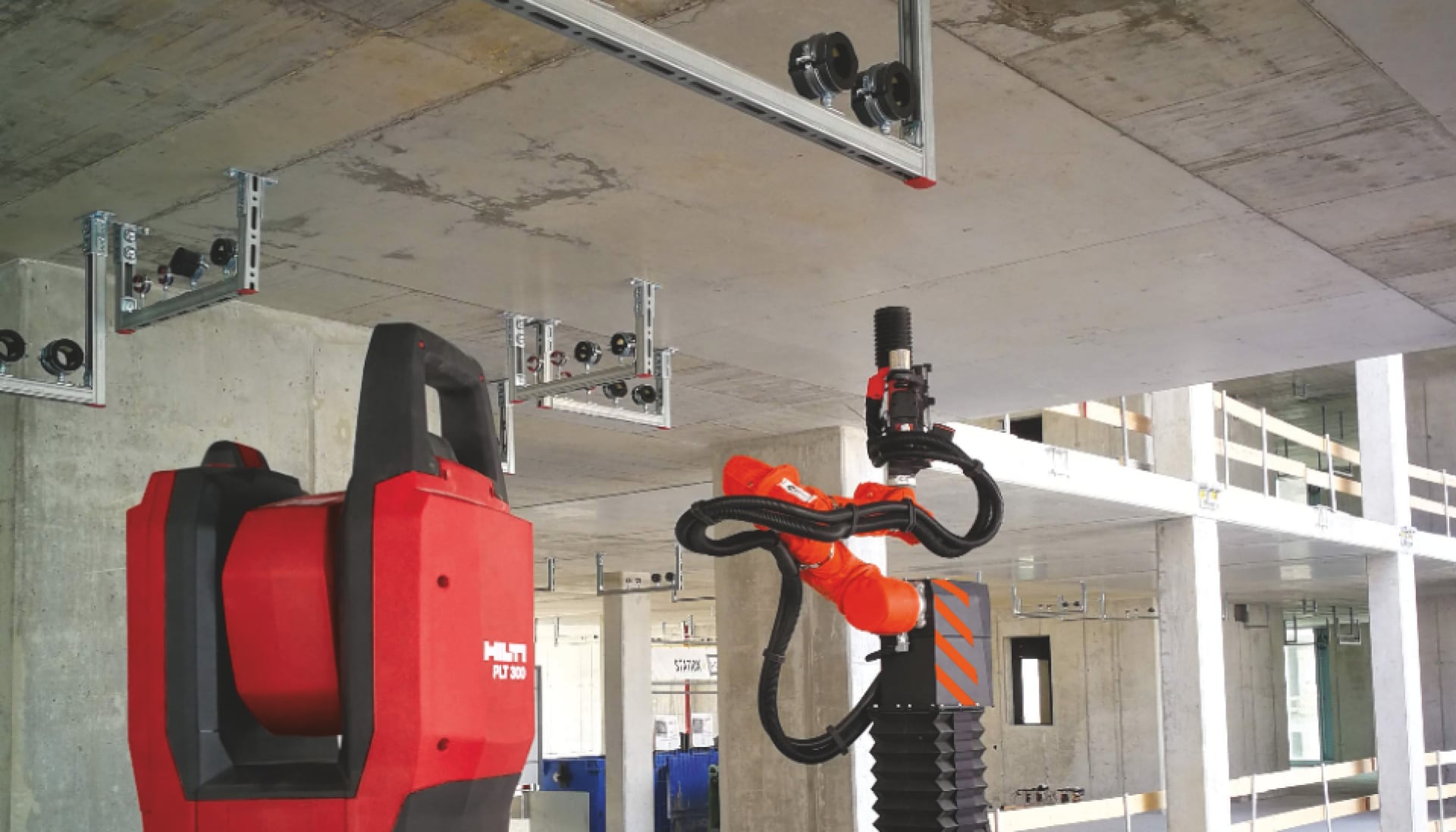 Hilti PLT 300 utsättningsverktyg och Jaibot borrobot utför installationslösningar på en byggarbetsplats.
