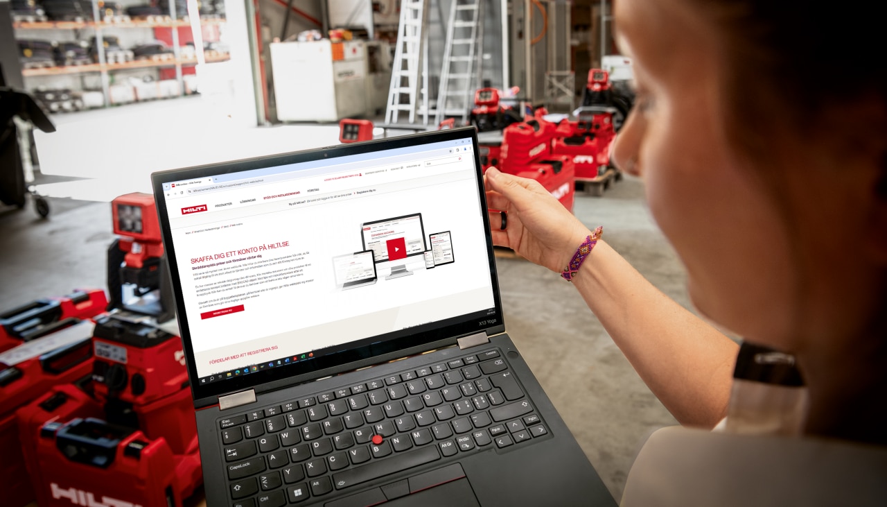 loggar in på laptop i ett lagerhus
