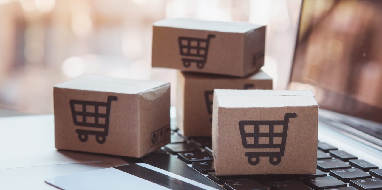 Shopping online. Credit card and cardboard box with a shopping cart logo on laptop keyboard. Shopping service on The online web. offers home delivery